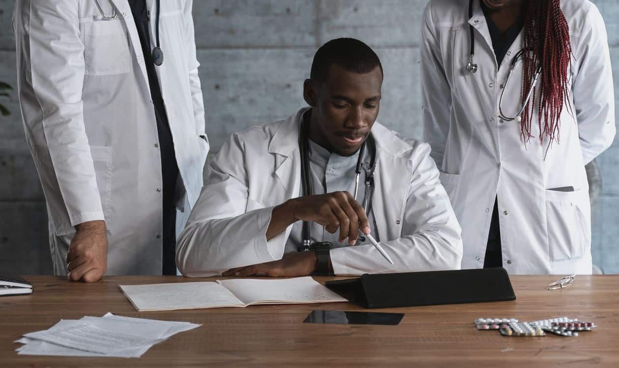 Medical team collaborating on research — beyond-volume-program-directors A diverse team of healthcare professionals collaborating on medical research in a modern clinical workspace