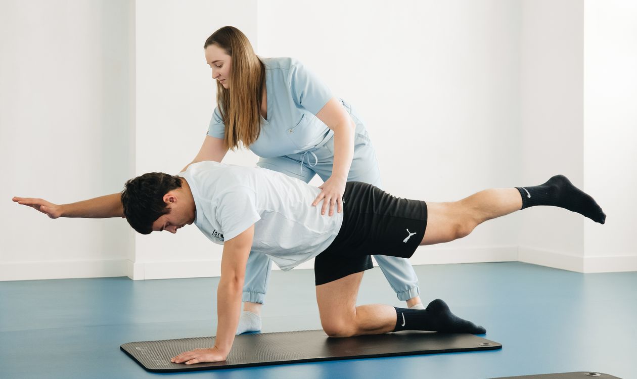 Physiotherapist with patient — mechanism-vs-preparation A physiotherapist assists a patient with exercises in a modern clinic setting